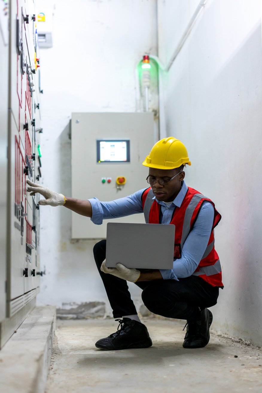 Electrical engineer working in control room. Electrical engineer man checking Power Distribution Cabinet in the control room